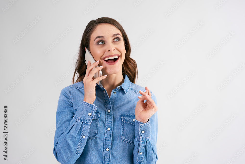 Happy, young woman using mobile phone in studio shot Happy, young woman using mobile phone in studio shot
