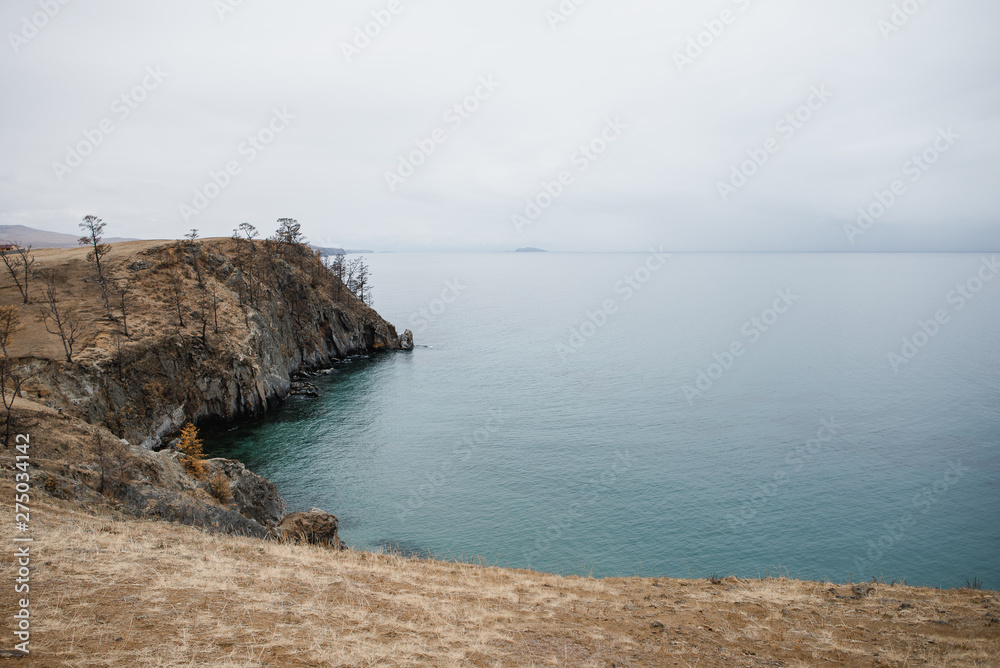cliffs breaking into the blue calm water of a clear lake cliffs breaking into the blue calm water of a clear lake