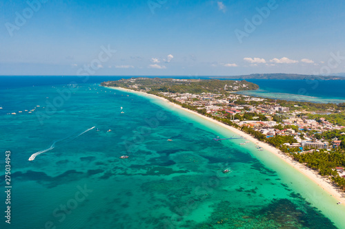 Fototapeta Naklejka Na Ścianę i Meble -  Many tourist boats near the island of Boracay. Seascape in the Philippines in sunny weather, view from above. A large densely populated island with hotels and a white beach.