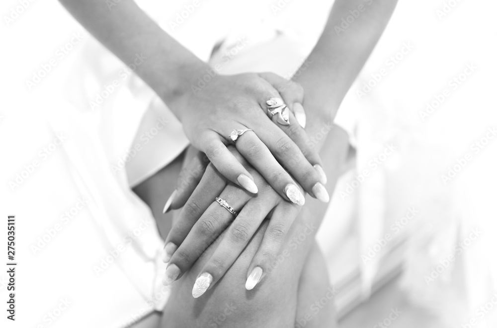 Bride in white clothes near the window. Beautiful manicure. Elegant nails. Golden rings. Wedding jewellery. Black and white. Bride in white clothes near the window. Beautiful manicure. Elegant nails. Golden rings. Wedding jewellery. Black and white.