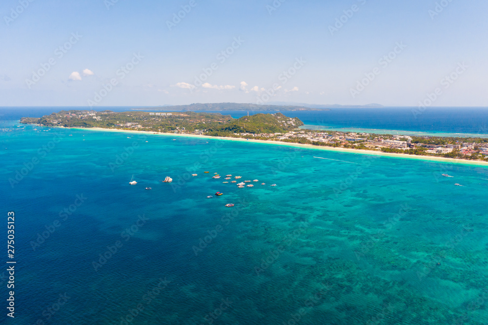Island Boracay, Philippines, view from above. White beach with palm trees and turquoise lagoon with boats. Buildings and hotels on the big island. Island Boracay, Philippines, view from above. White beach with palm trees and turquoise lagoon with boats. Buildings and hotels on the big island.