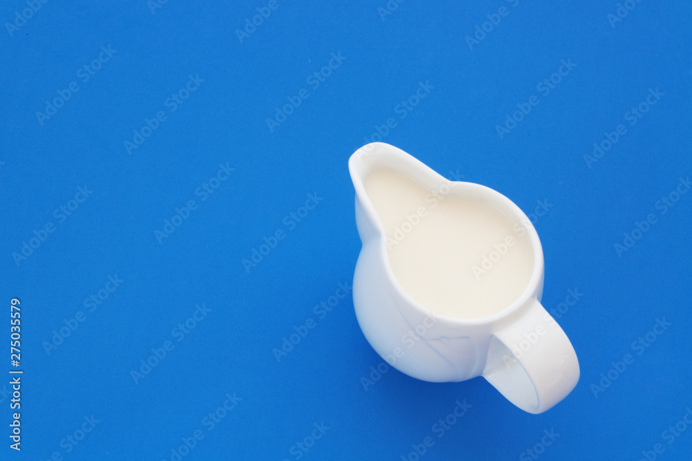 Fresh milk in jug on blue background with space for text, top view Fresh milk in jug on blue background with space for text, top view