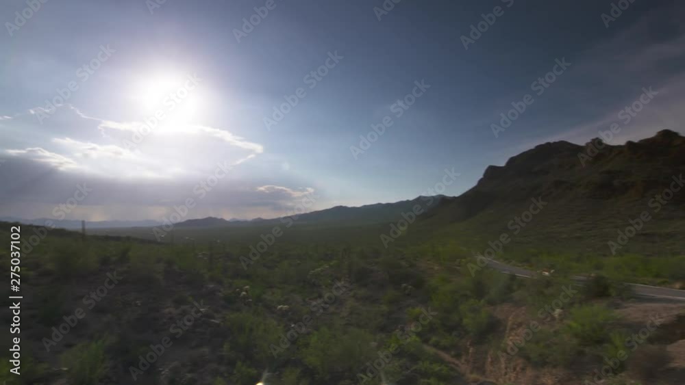 Handheld, wide shot of a road next to a mountain, camera pans to reveal another mountain to the left. Handheld, wide shot of a road next to a mountain, camera pans to reveal another mountain to the left.