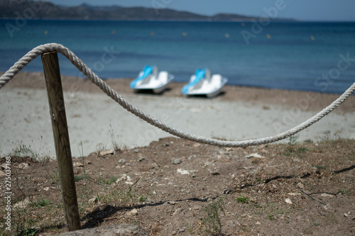 Pedalos in the background, nautical rope in the foreground photo