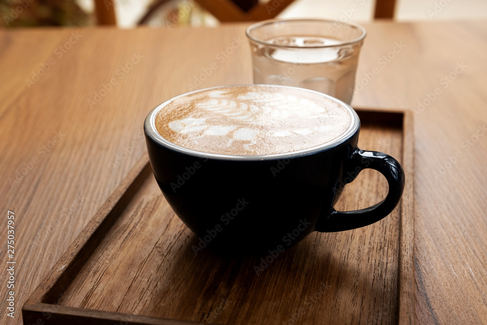 Hot latte with beautiful latte art on the wooden table Hot latte with beautiful latte art on the wooden table