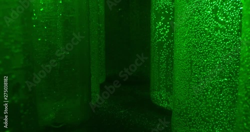 Cooled Wet Green Beer Bottles, Slow Motion Against Black And Grey Background. Macro. 4K.