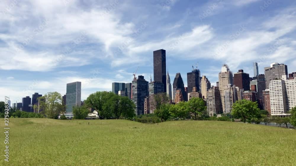 View of Manhattan from grassy area on Roosevelt Island with United Nations in background. View of Manhattan from grassy area on Roosevelt Island with United Nations in background.