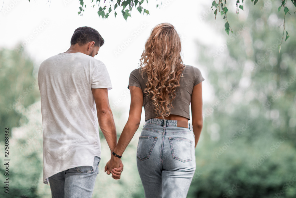 Couple in love walking in park holding hands Couple in love walking in park holding hands