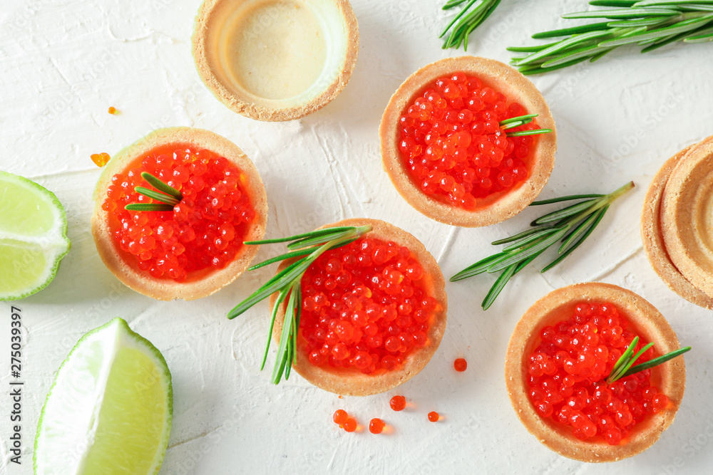 Tartlets with caviar, rosemary and limes on white background, top view Tartlets with caviar, rosemary and limes on white background, top view