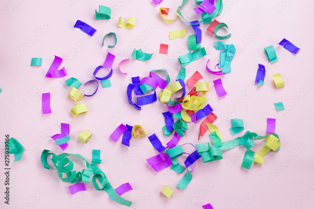 Multicolored paper confetti on a pink background. Party and holiday concept Multicolored paper confetti on a pink background. Party and holiday concept