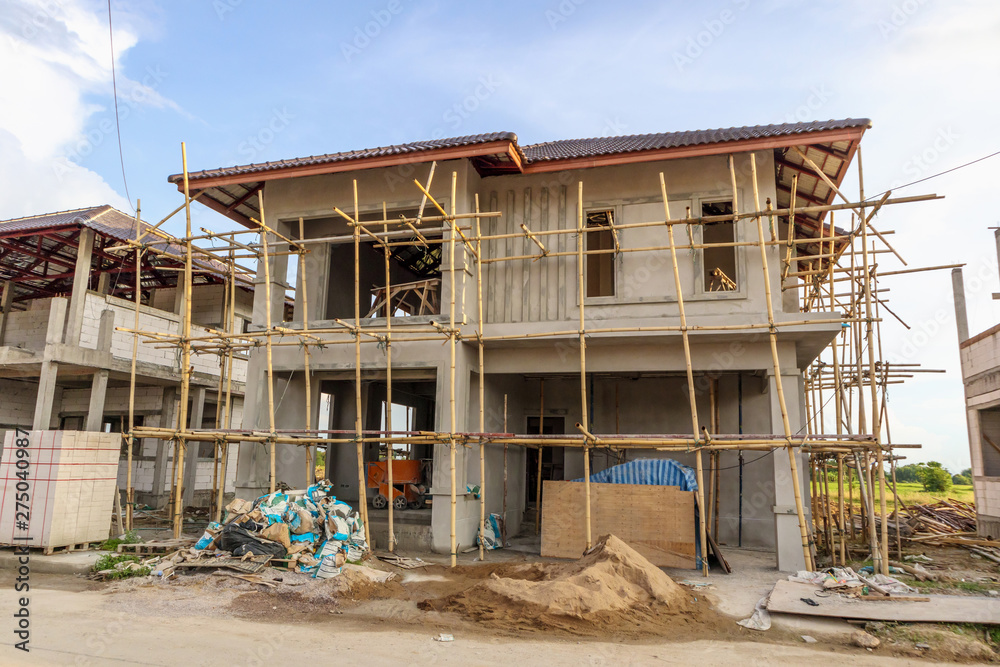 construction residential new house in progress at building site with clouds and blue sky construction residential new house in progress at building site with clouds and blue sky