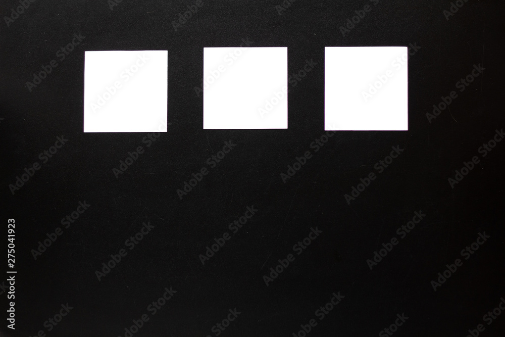 three white blank stickers, board from writing or lettering with white stickers and black background three white blank stickers, board from writing or lettering with white stickers and black background