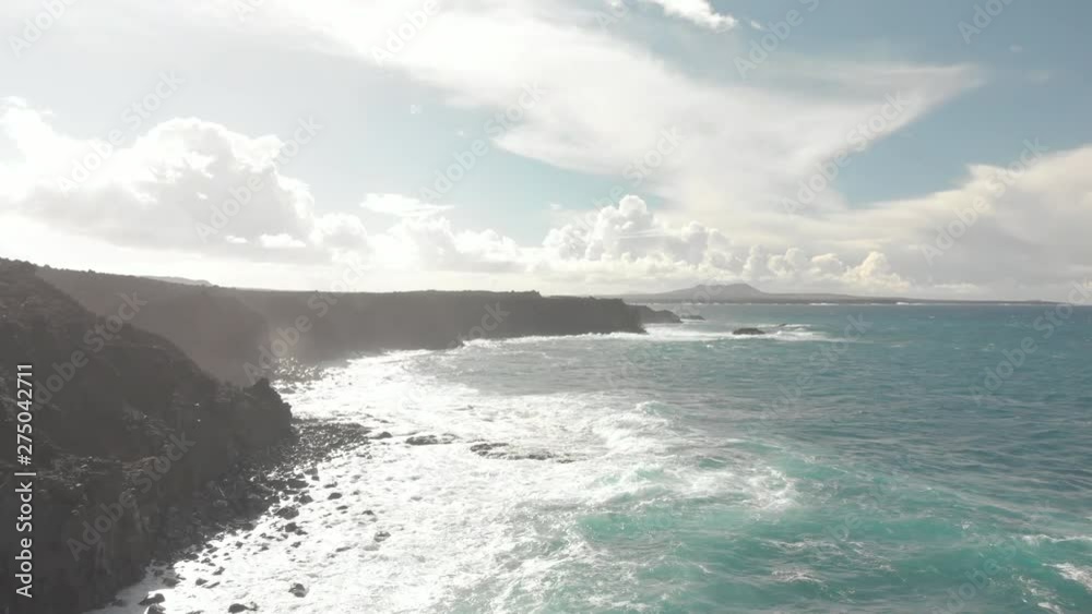 Flight over black coast facing the sea and the waves