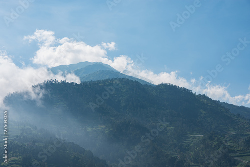 mountain peak rising up into the clouds in Asia.