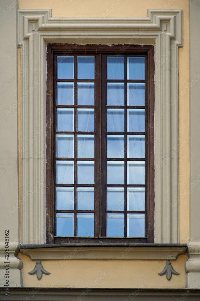  Architecture details. Beautiful window in the brick palace castle. The reflection in the glass of the sky and buildings  