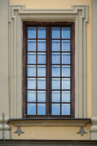  Architecture details. Beautiful window in the brick palace castle. The reflection in the glass of the sky and buildings 
