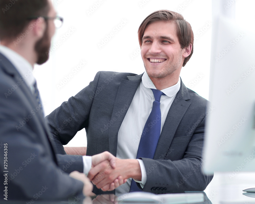 close up. handshake business partners sitting at the Desk close up. handshake business partners sitting at the Desk