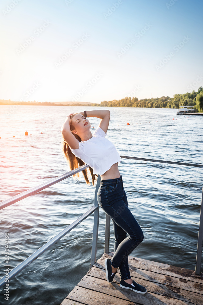 Young woman against sunset and lake water