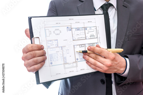 Male hands with clipboard and house plan on it