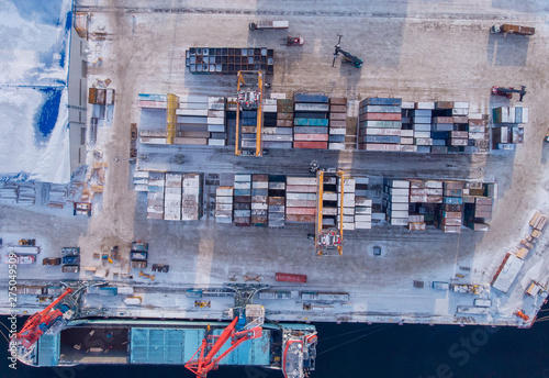 Commercial north arctic port is loading containers onto cargo tanker ship. Concept logistics and delivery of goods