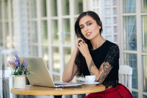 Beautiful girl businesswoman working on laptop in cafe, female freelancer