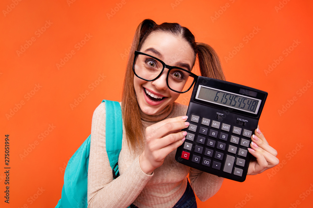 Close up photo beautiful she her lady hold hands arms calculator best exam result lesson toothy lottery lucky blue back pack wear specs casual pastel pullover clothes isolated orange background Close up photo beautiful she her lady hold hands arms calculator best exam result lesson toothy lottery lucky blue back pack wear specs casual pastel pullover clothes isolated orange background