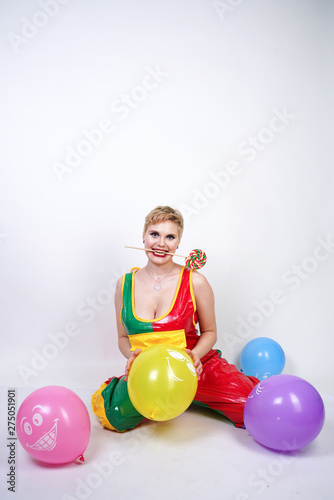 funny happy clown girl with colorful air ballons on white studio background
