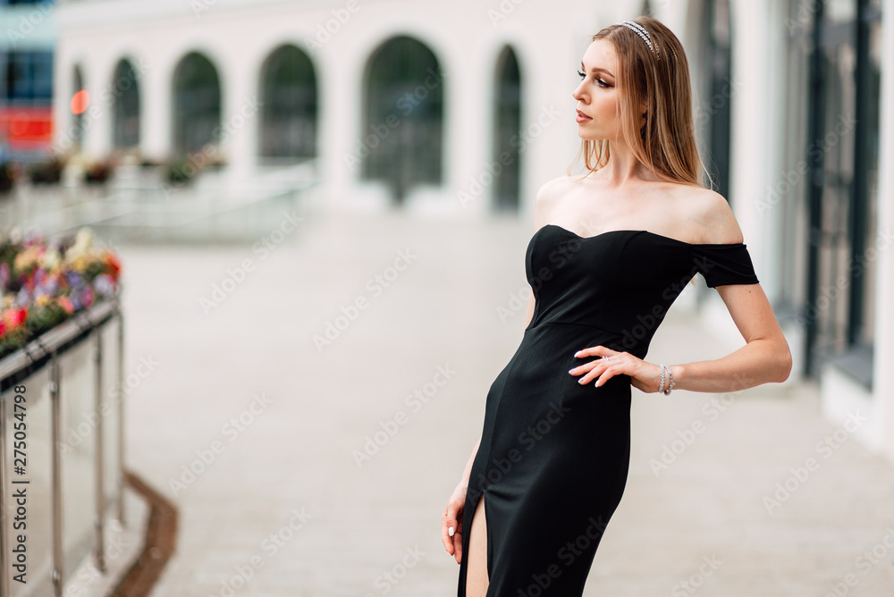 beautiful young girl in black dress walking the streets of the city, the woman is resting outdoors, street fashion. urban lifestyle. beautiful young girl in black dress walking the streets of the city, the woman is resting outdoors, street fashion. urban lifestyle.