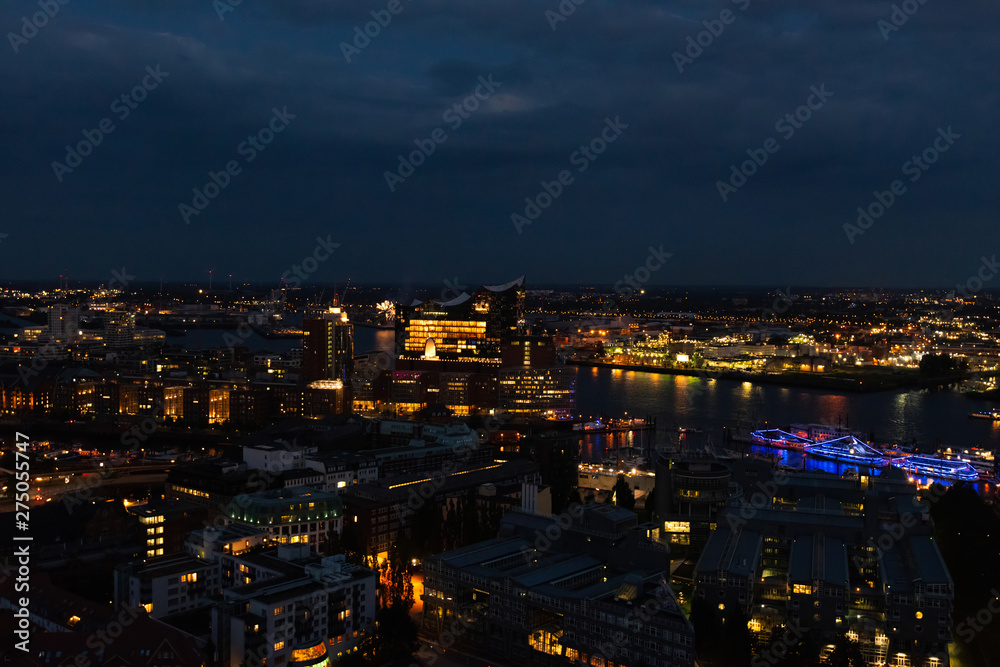 Aerial view of Hamburg, Germany in the evening with fireworks next to the new Elbphilharmony (Elphi) and illuminated boats