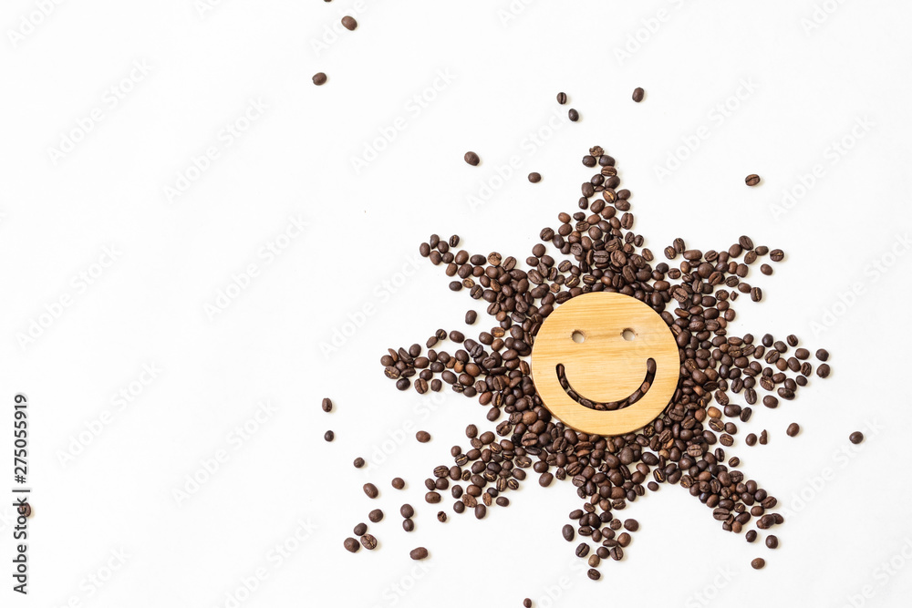 Coffee is a healthy, mood-enhancing drink. Star or sun from roasted coffee beans with a smile in the middle on a white background Coffee is a healthy, mood-enhancing drink. Star or sun from roasted coffee beans with a smile in the middle on a white background