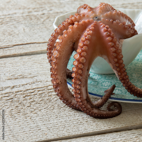 Top view of boiled octopus on rustic wooden background. Typical Mediterranean protein food  space for text.