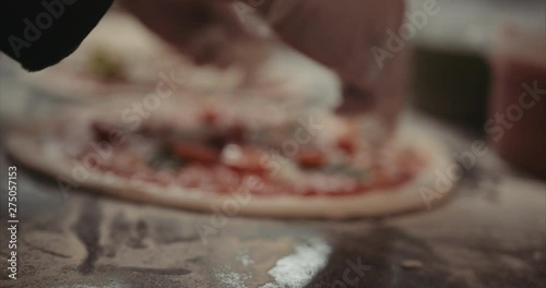 Placing toppings on a Neapolitan margherita pizza. Authentic Neapolitan Pizza cooked in a wood fire oven.