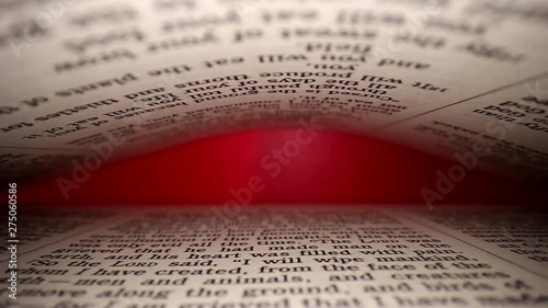 Slowly pulling lens out of book. Words eye view of the pages, on both top& bottom. Centered middle focus, at the end page is highlighted by red light. photo