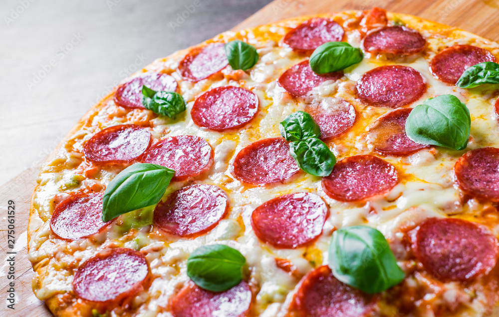 Pepperoni Pizza with Mozzarella cheese, salami, Tomato sauce, pepper, Spices and Fresh basil. Italian pizza on wooden table background Pepperoni Pizza with Mozzarella cheese, salami, Tomato sauce, pepper, Spices and Fresh basil. Italian pizza on wooden table background