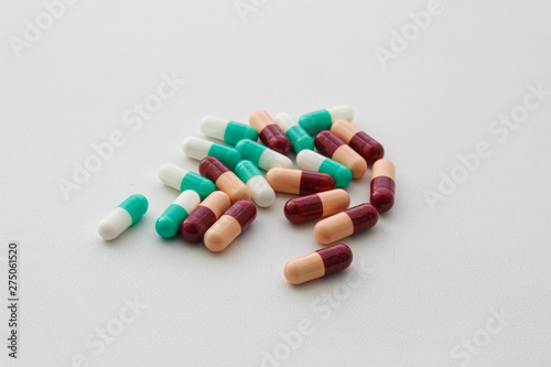 multicolored capsules on a white background in the center