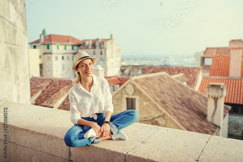 Traveling by Croatia. Young traveling woman enjoying old town Split view, red tiled roofs and ancient architecture.