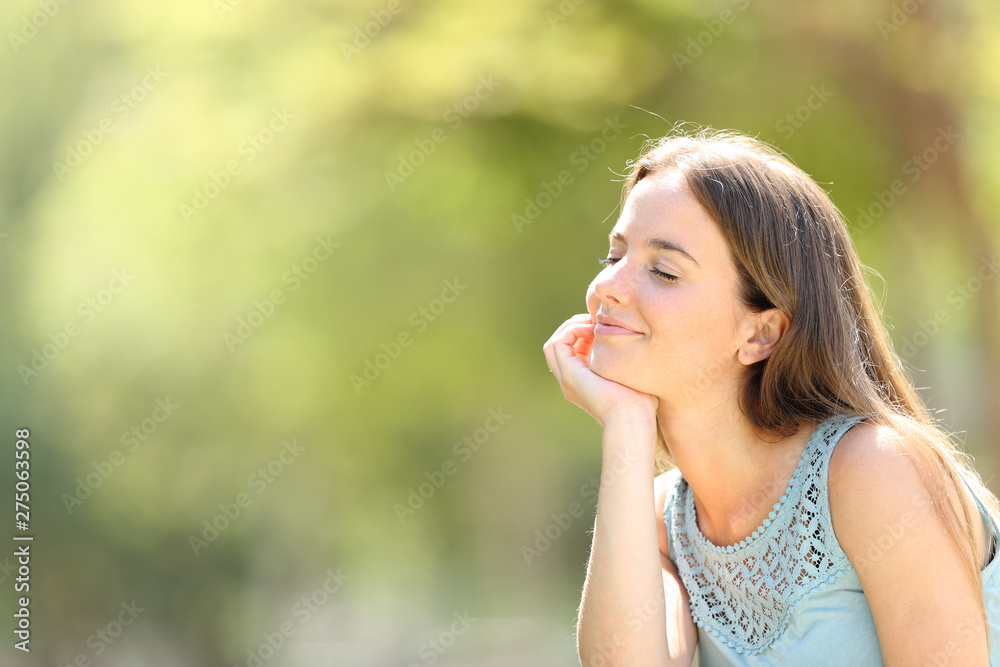 Smiley woman meditating and relaxing in a forest Smiley woman meditating and relaxing in a forest