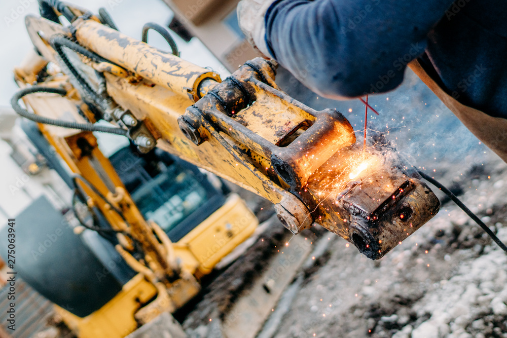 Close up portrait of mechanical engineer working and welding excavator Close up portrait of mechanical engineer working and welding excavator