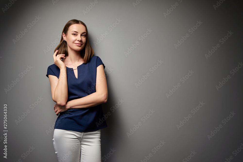 Confident young business woman looking at camera. Grey background with copy space. Confident young business woman looking at camera. Grey background with copy space.