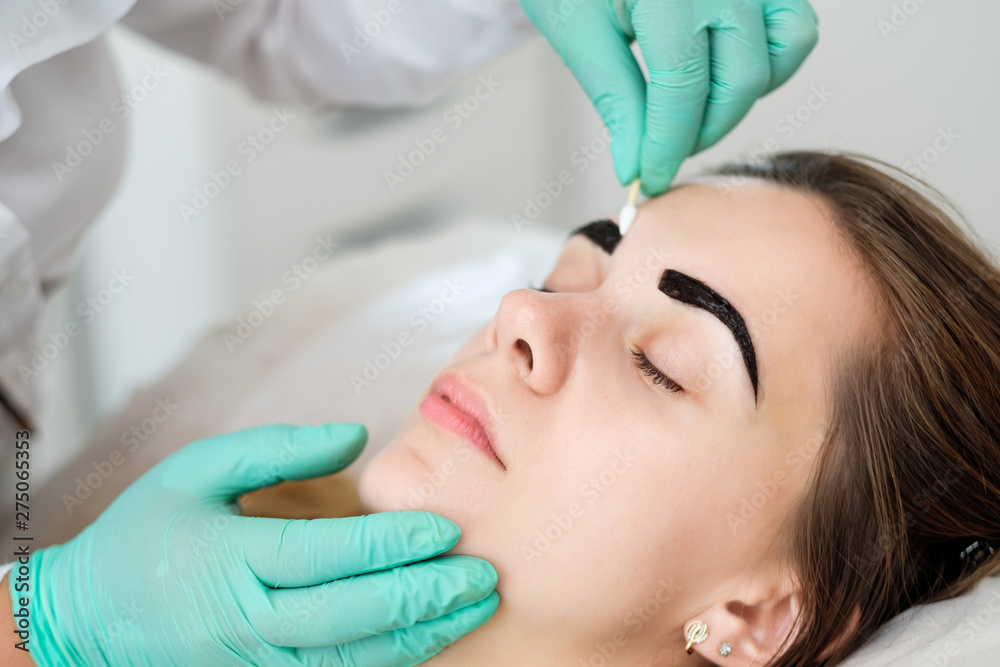 Beautician performing henna brows correction Beautician performing henna brows correction