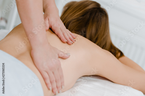 Massage natural session: woman receiving back massage from professional masseur