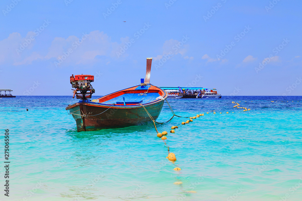 Long tailed boat at  kho lipe satun Thailand/Fishing boat on the sea and blue sky background at  kho lipe satun Thailand/Tropical beach kho lipe satun Thailand wooden long tailed boat on the sea/ 