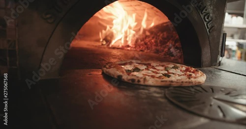 Pizza being moved around in a wood fire oven to get optimal char. Authentic Neapolitan Pizza cooked in a wood fire oven.