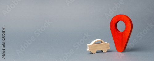 Photographie Wooden car figure drive near a red pin location marker