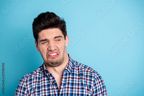 Close up photo amazing he him his macho disgusted look side empty space awful awkward situation spoiled eat food white teeth wear casual checkered plaid shirt isolated bright blue background