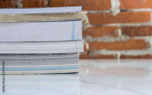 Stack of hardcover books on table against marble background, space for text