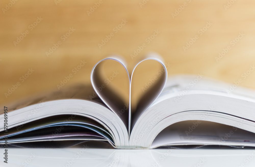 Bible on table with pages folded into heart shape Bible on table with pages folded into heart shape