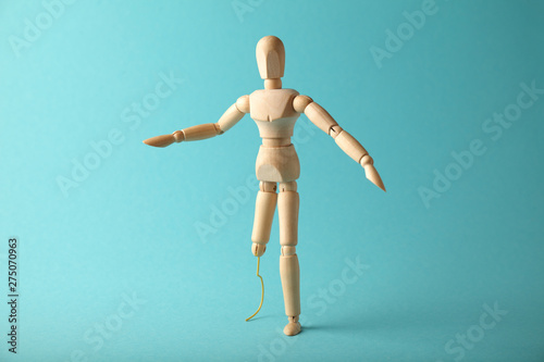 Wooden figure of man with artificial prosthetic leg. Amputee and disability concept. photo