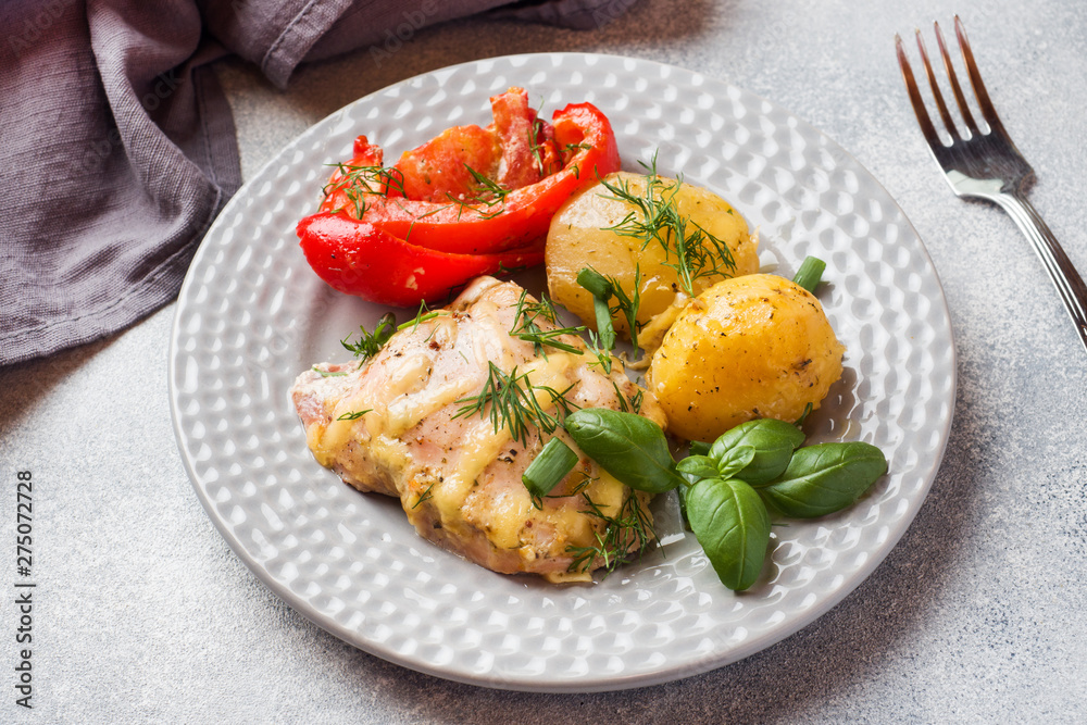 Baked potatoes with chicken and vegetables on a plate.