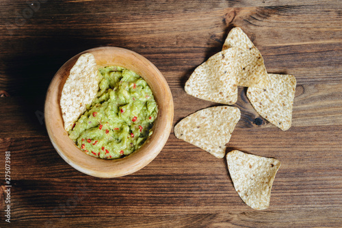 traditional guacamole with nachos on rustic table